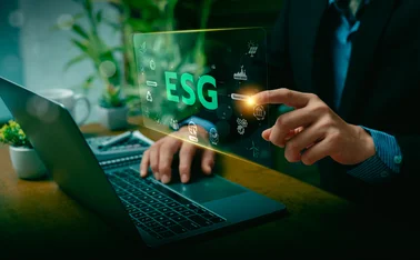 ESG letters over a man sitting in front of a screen