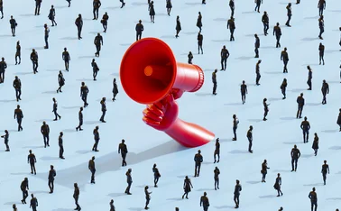 Hand holding large red megaphone in a crowd of people