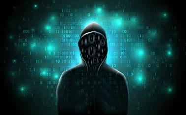 Silhouette of a hacker in a hoodie made up of binary code