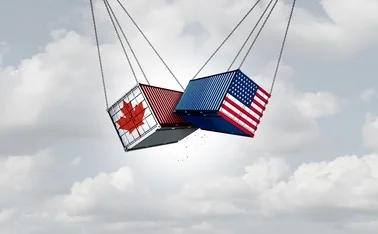 Two cargo container smash into each other. One is painted with a Canadian flag, the other with a US flag. 