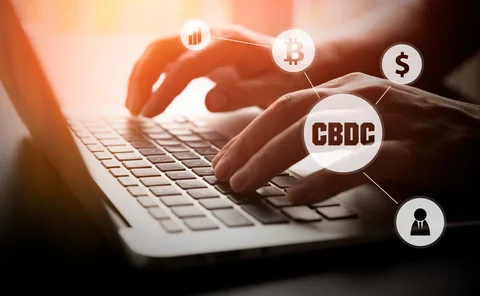 Hands typing on a laptop with digital money symbols