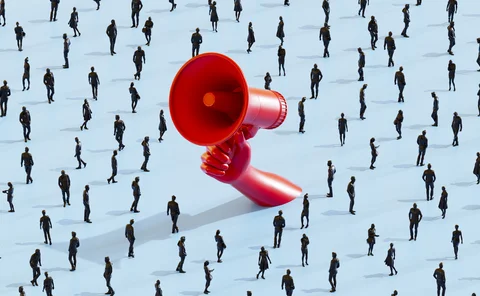 Hand holding large red megaphone in a crowd of people