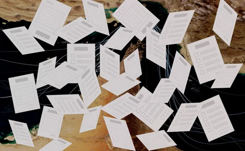 Exam papers fly randomly in front of a backdrop of the strait of hormuz