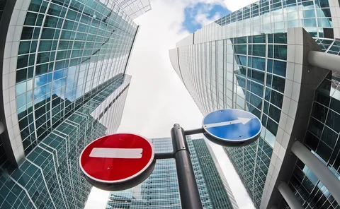 No-entry and diversion road signs on a background of distorted skyscrapers