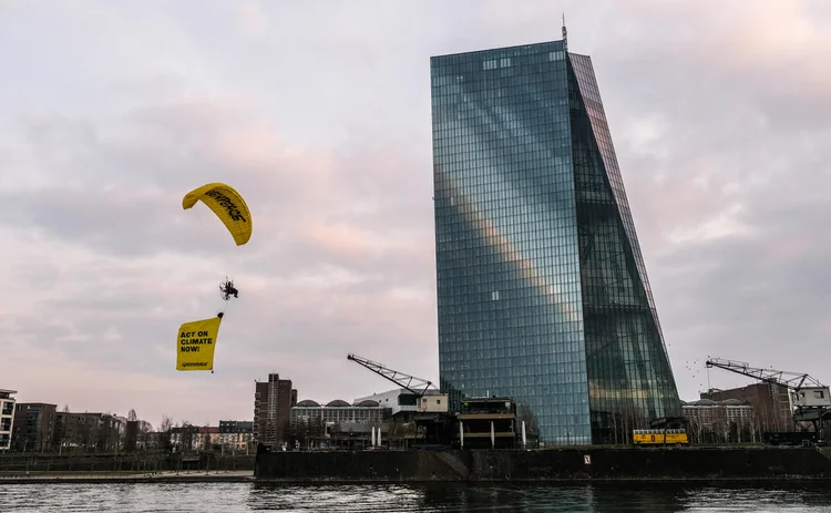 A Greenpeace protester paraglides past the ECB headquarters
