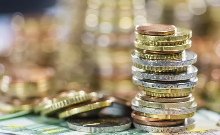 Pile of euro coins on top of banknotes
