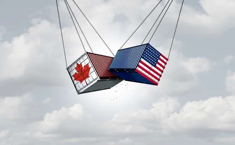Two cargo container smash into each other. One is painted with a Canadian flag, the other with a US flag. 