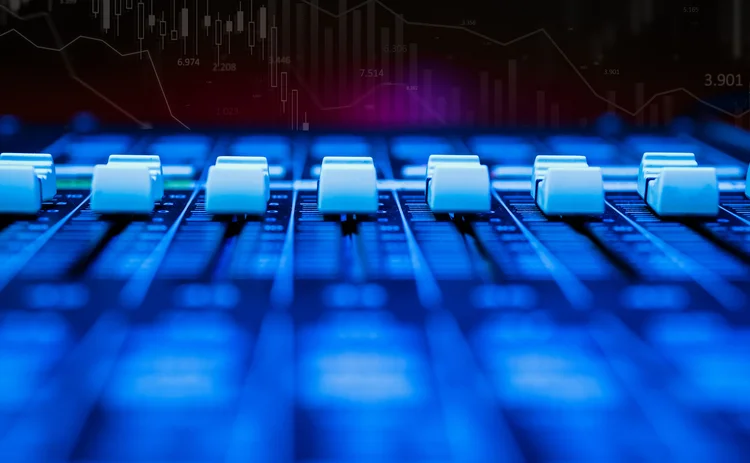 Mixing desk equalisers below a trading chart backdrop