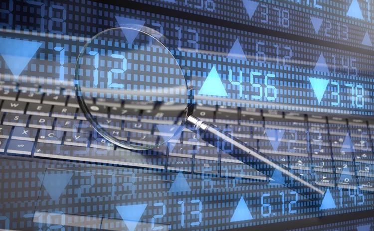 Magnifying glass over computer screen showing numbers