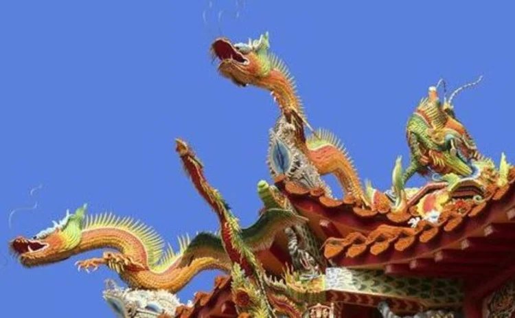 chinese-dragons-three-on-gate-top-orange-against-blue-sky