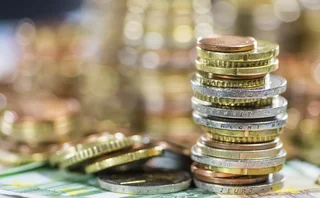 Pile of euro coins on top of banknotes