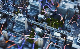 An aerial view of city buildings with bright curved lines connecting them