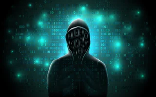 Silhouette of a hacker in a hoodie made up of binary code