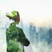 Silhouette of woman filled with greenery looking over a city scape