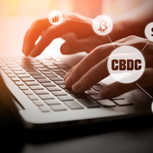 Hands typing on a laptop with digital money symbols