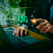 ESG letters over a man sitting in front of a screen