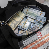 Duffel bag full of dollar banknotes with law enforcement badge and evidence bags